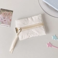 Detail of white quilted storage pouch with 3D butterfly embroidery and zipper closure - White
