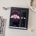 Macro detail of black Y2K photocard album with pink angel text and butterfly wing pendant - An Angel Descends Style (Black) / Black
