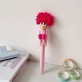 Close-up of creative pink robot boxing pen with soft magenta plush fur on a clean desk - Pink Afro