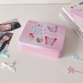Detail of a vintage pink gradient tin box with butterfly and rose illustrations on a desk - Three Butterflies