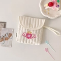 Detail der rosa Herzbestickung auf der cremefarbenen gesteppten Tasche mit Handschlaufe - Rosa Herz