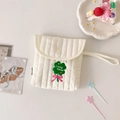 Detailaufnahme der gesteppten beigen Damenhygiene-Tasche mit Kleeblatt-Stickerei und Handschlaufe - Grünes Kleeblatt