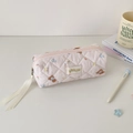 Close-up of pink quilted makeup pouch with cute bear pattern and silk ribbon zip pull - Pink