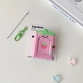Nahaufnahme des Erdbeer-Mini-Fotoalbums mit grünem Karabinerverschluss und Perlenkette - Rosa