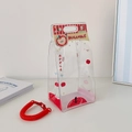 Detail der transparenten PVC-Tasche mit rotem Apfelmuster und gestreiftem Rand mit Band - Roter Apfel