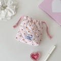 Detailed close-up of a pink checkered quilted drawstring bag with cherry patterns - Pink