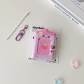 Close-up of a mini strawberry photo album keychain with purple clasp and snap closure - Purple