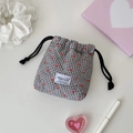 Macro detail of plaid drawstring bag with cherry print and quilted texture - Black