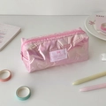 Vue détaillée de la trousse rose à motif d'étoiles matelassées sur un bureau blanc - Rose Perlé