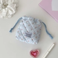 Close-up of blue gingham quilted drawstring pouch featuring a pink cherry print pattern - Blue