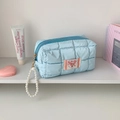 Dettaglio della pochette trapuntata azzurra con etichetta a cuore rosa e zip di perle - Blu
