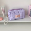 Close-up of light purple quilted cosmetic bag with pearl strap and heart label - Purple