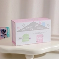 Detailed view of pink polka dot storage box with house design on cream display stand - Pink White