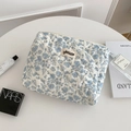 Quilted floral makeup bag with blue flower pattern on white cotton fabric close-up - Blue Floral - Medium