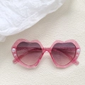 Detail der herzförmigen Kinder-Sonnenbrille in Pink mit Glitzer und Perlenbesatz - Transparentes Rosa