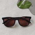 Classic square black sunglasses with brown gradient lenses in a summer resort setting - Dark Brown