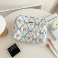 Détail macro de la trousse de maquillage matelassée aux nœuds bleus et fleurs - Bleu Nœud Floral Moyen