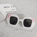 White children sunglasses with pink rhinestones and black lenses on stone background - White