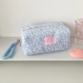 Detail of light blue leopard print plush pouch with soft faux fur texture and pink woven label - Blue