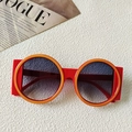 Occhiali da sole rotondi oversize con montatura rossa e arancione su sfondo strutturato - Arancione