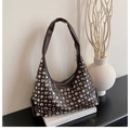 Primer plano detallado de un bolso hobo de cuero marrón vintage con remaches metálicos plateados - Marrón