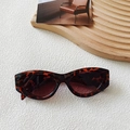 Retro-Cat-Eye-Sonnenbrille in Schildpatt-Optik mit dunklen Gläsern auf weißem Hintergrund - Leopardenmuster