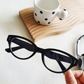 Fashionable black cat eye sunglasses with silver rivets on a minimalist wooden tray - Black Frame Clear Lenses