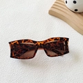 Schicke Schildpatt-Sonnenbrille in Rechteckform mit braunen Gläsern auf modernem Hintergrund - Leopardenmuster