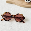 Lunettes de soleil polygonales en écailles avec verres bruns sur un fond texturé blanc - Écaille de tortue