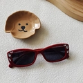Deep red vintage oval sunglasses with rhinestone accents on a textured surface - Burgundy
