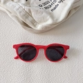 Rode ronde zonnebril voor baby's met donkere glazen op een witte getextureerde basis - Blauw
