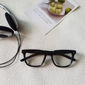 Lunettes enfants noires à monture carrée avec détails étoilés sur fond texturé blanc - Lunettes de Mode à Verres Transparents / Monture Noire Verres Transparents