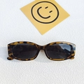 Ovale Sonnenbrille in Schildpatt-Optik mit dunklen Gläsern auf weißem Hintergrund - Leopardenmuster