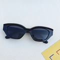 Gafas de sol cat-eye negras modernas con lentes UV400 sobre una superficie blanca - Negro y Gris
