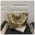 Dettaglio di grandi paillettes dorate e spalline sottili su una borsa tote chic - Oro