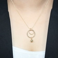 Nahaufnahme des geometrischen Doppelkreis-Anhängers mit Metallperle an Goldkette - Doppelring Verschachtelter Massiver Rundperlen Stil (2#)