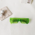 Top view of green translucent rectangular sunglasses on artistic props and white background - Green Transparent Rectangular Thick Frame (Jewel Green 3)