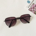 Detalle de gafas de sol de metal con lentes degradadas en violeta sobre superficie texturizada - Gris Doble