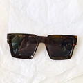 Top view of square tortoiseshell sunglasses with dark lenses on a white textured base - Tortoise