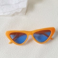 Close-up of retro cat-eye sunglasses with bright orange frame and blue tinted lenses - Bright Orange Frame Blue Lens