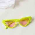 Detail of neon green cat-eye sunglasses with translucent pink lenses on a white background - Neon Green Frame Pink Lens