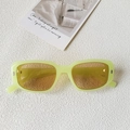Détail de lunettes de soleil carrées vert néon avec rivets sur fond texturé blanc - Vert Gelée