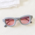 Detail of grey bubble frame cat eye sunglasses with transparent pink lenses on white texture - Premium Grey
