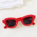 Detailed top view of red chunky cat eye sunglasses with dark lenses on a white surface - Red
