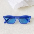 Close-up of bright blue retro cat-eye sunglasses on a white textured background - Blue Frame / Blue Lens