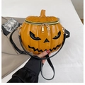 Close-up of 3D pumpkin crossbody bag featuring glossy orange finish and demon face detail - Yellow