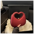 Detailed view of burgundy heart-shaped matte handbag with gold chain on white satin - Red