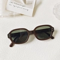 Detailansicht der ovalen braunen Sonnenbrille mit dunkelgrünen Gläsern und Silbernieten - Dunkelgrüner Rahmen