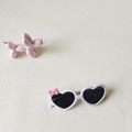 Weiße herzförmige Kinder-Sonnenbrille mit rosa Schleife und schwarzen Polgläsern - Weiß