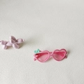 Rosafarbene Kinder-Sonnenbrille in Herzform mit einer mintgrünen Schleife am Rahmen - Rosa